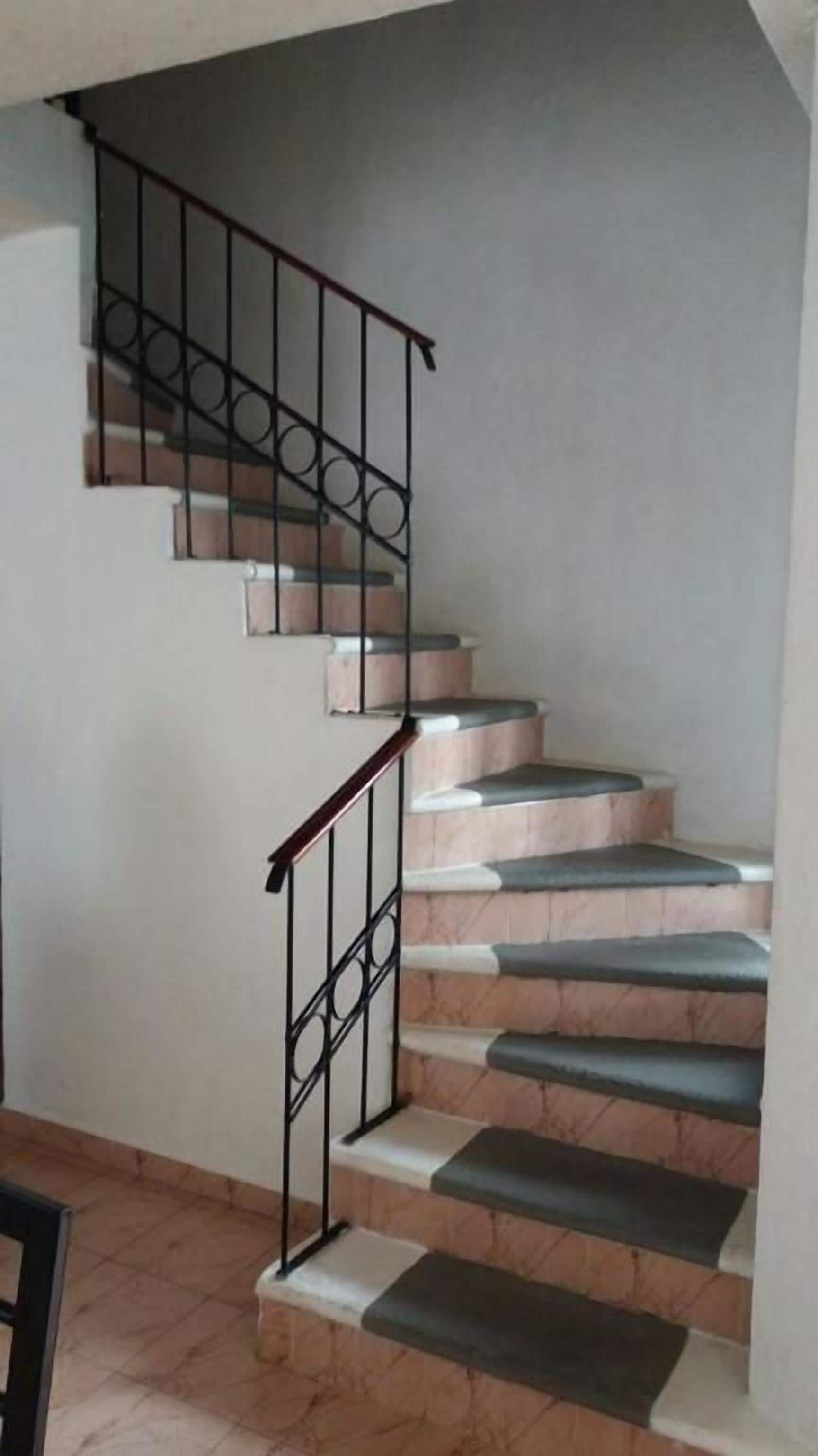 Un escalier avec une rampe et des marches en métal.