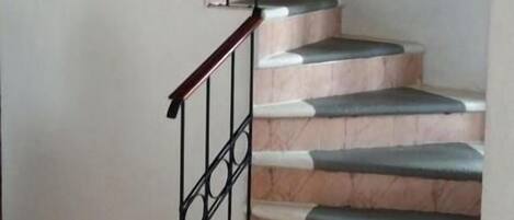 Una escalera con barandilla de metal y peldaños.