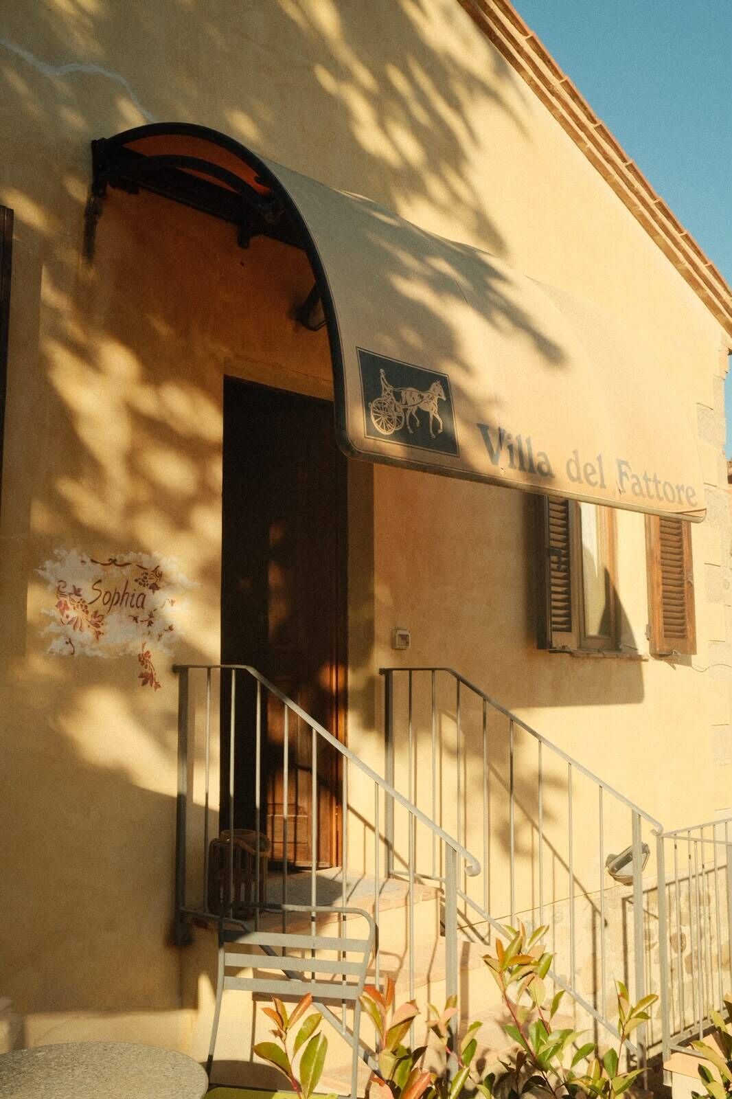 Ein Gebäude mit einem Schild, auf dem 'Villa del Fattore' steht, einer Treppe und einer kleinen Außenbereich-Sitzgelegenheit.