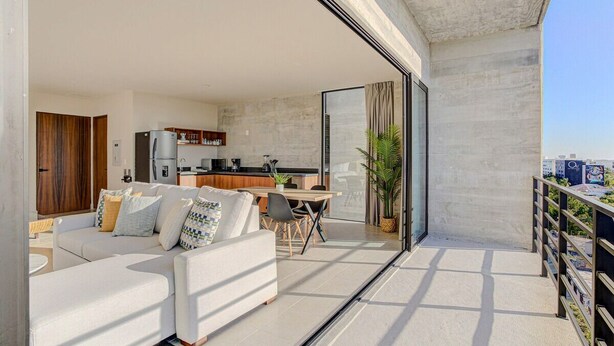 Un apartamento moderno con sala de estar, cocina y balcón.