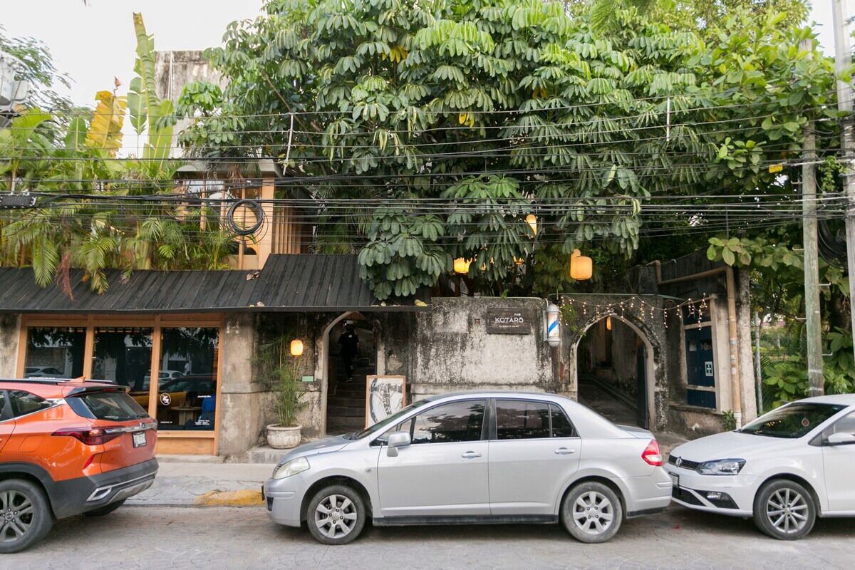 A building with a sign reading 'KOTARO' and a car parked in front.