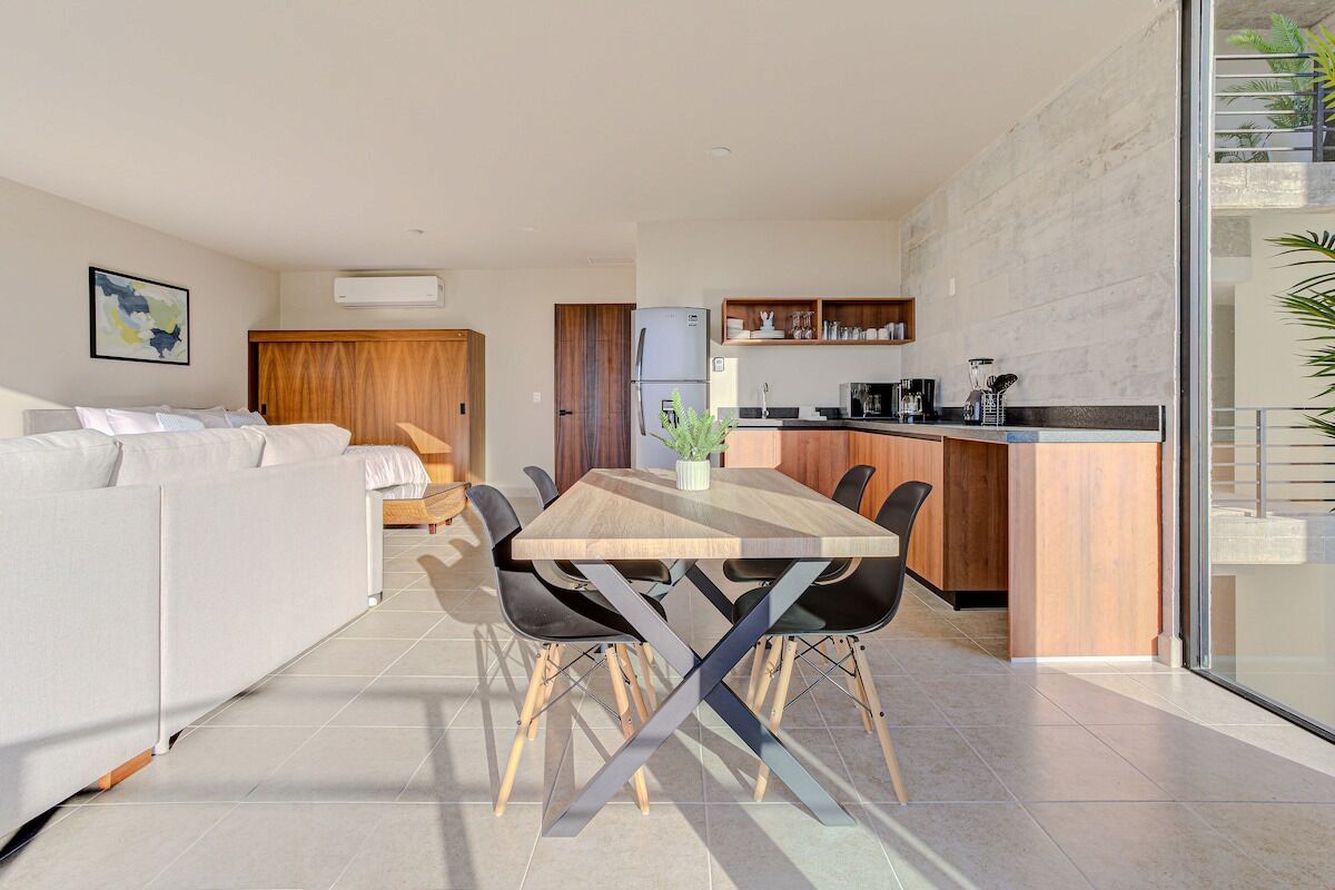 A modern apartment with a dining area, kitchen, and living space.
