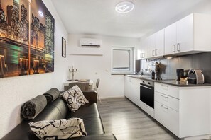 Eine moderne Küche mit weißen Schränken, einem Backofen und einer Kaffeemaschine.