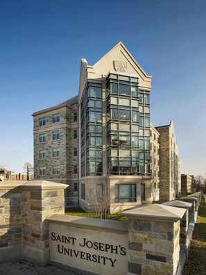 Un edificio de varios pisos con fachada de piedra y ventanas grandes, con la leyenda 'Saint Joseph's University'.