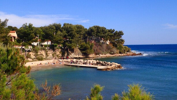 A coastal area with a beach, rocky shoreline, and buildings on a hillside. - In the heart of the Calanque du Cap Rousset—Apartment with a sea view, perfect for a romantic getaway! (Carry-le-Rouet)