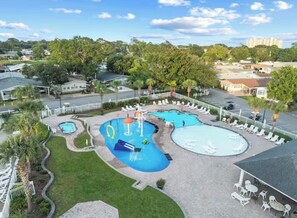 Et resort med flere swimmingpools, liggestole og palmer.