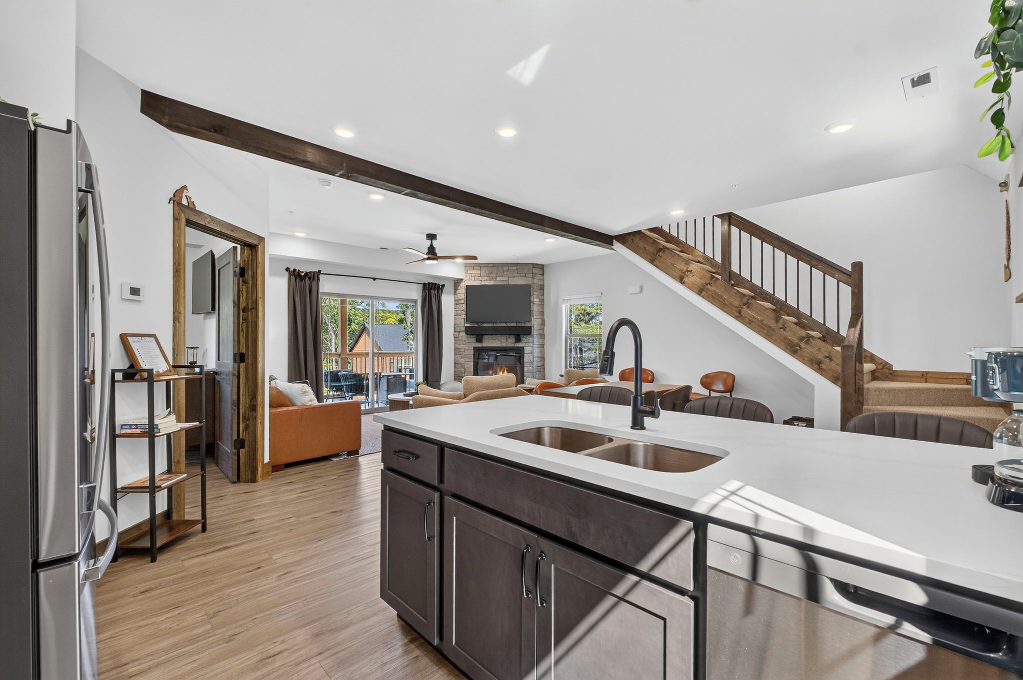 A modern kitchen with a central island, built-in appliances, and a stone fireplace.