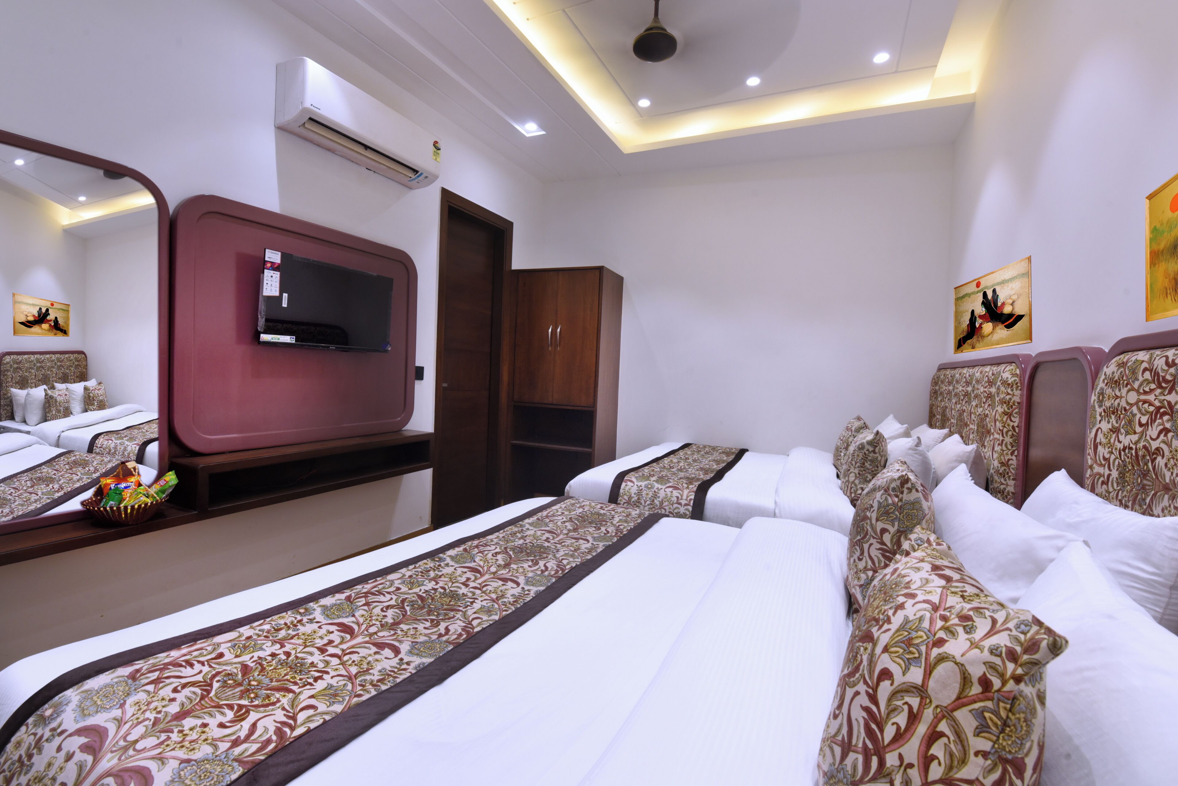 Une chambre d’hôtel avec un grand lit, une télévision, une armoire et une porte de salle de bain.