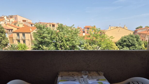 Ein Tisch für zwei Personen mit Blick auf Gebäude und Bäume.