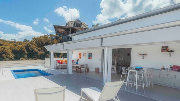 A modern house with a swimming pool, outdoor seating, and a covered patio area. - Villa for 10 guests, private pool and AC (Saint-Paul)