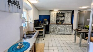 Une cuisine de taille réduite équipée d’un four à micro-ondes, d’une cuisinière et de placards.