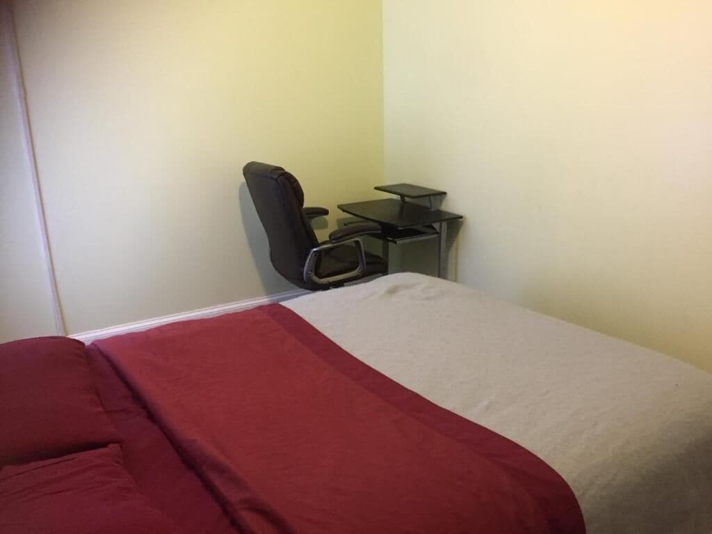 Habitación de hotel con una cama, un escritorio y una silla.