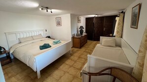 A bedroom with a bed, bedside table, lamp, dresser, and a chair. - Family home in a small but quiet tourist village (VC)