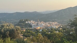 A town with buildings and hills in the background. - Family home in a small but quiet tourist village (VC)