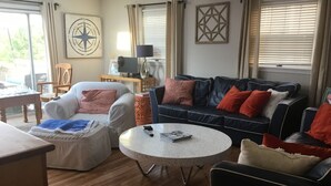 A living room with a sofa, a coffee table, and a TV. - Ocean Block.  Amazing 5-bedroom house with AC in charming Spring Lake! (Spring Lake)