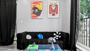 A room with a black sofa, a colorful coffee table, and two artworks on the wall. - Spacious 2-bedroom apartment in fabulous Philadelphia with AC (Philadelphia)