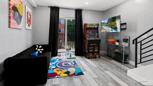 A modern living room with a black sofa, colorful rug, gaming console, and artwork on the walls. - Spacious 2-bedroom apartment in fabulous Philadelphia with AC (Philadelphia)