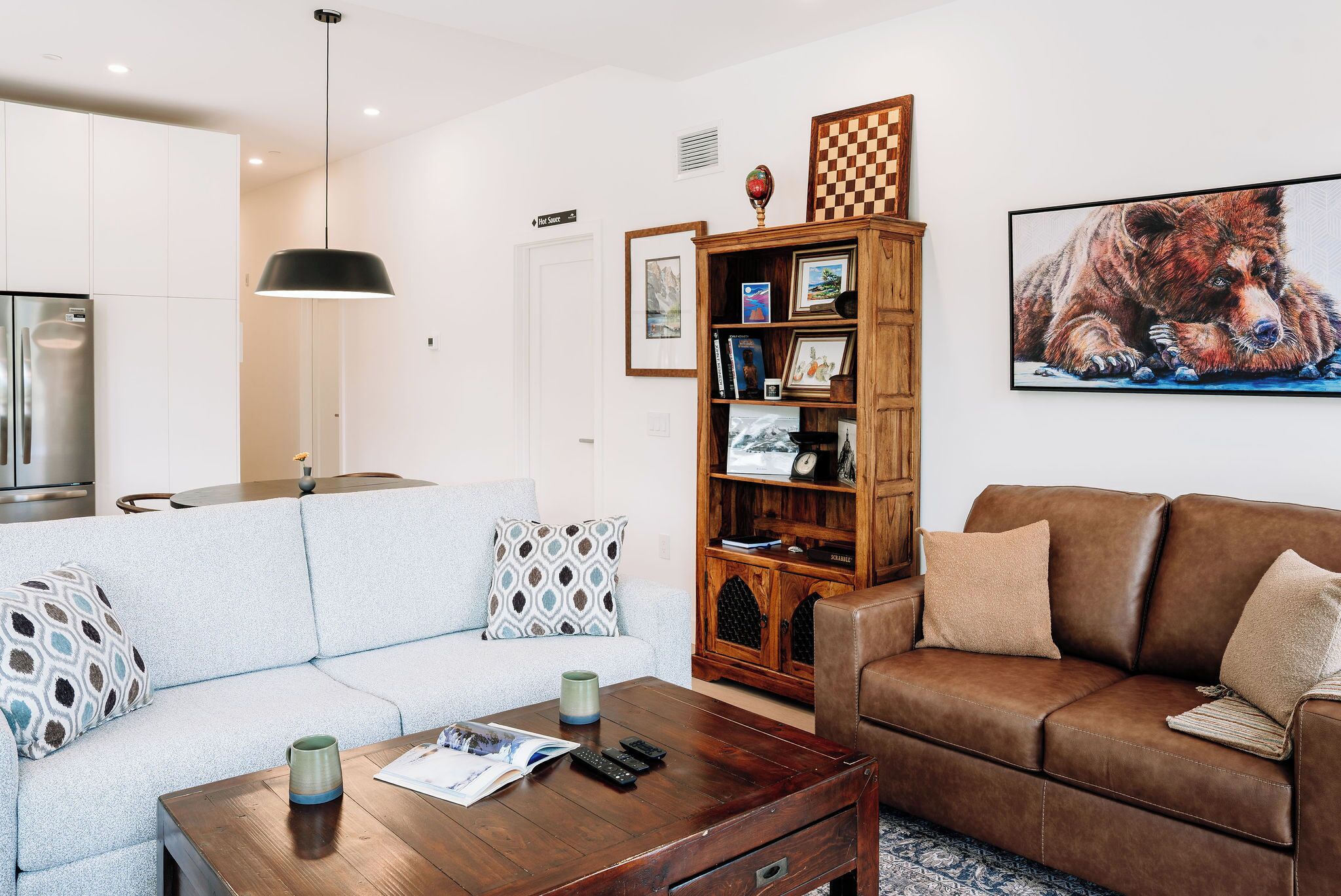 Un salon moderne avec un canapé, une table basse, une bibliothèque et un tableau.