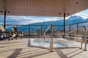 A hot tub with a view of mountains, wooden deck, and Adirondack chairs. - Hot Sauce Hideaway -Revelstoke Vacations (Revelstoke)