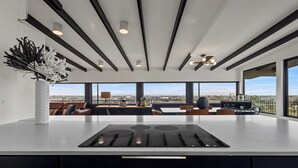 A modern kitchen with a central island, large windows, and a view of the cityscape. - S Haus: Elevated Desert Retreat Breathtaking Views (Phoenix)