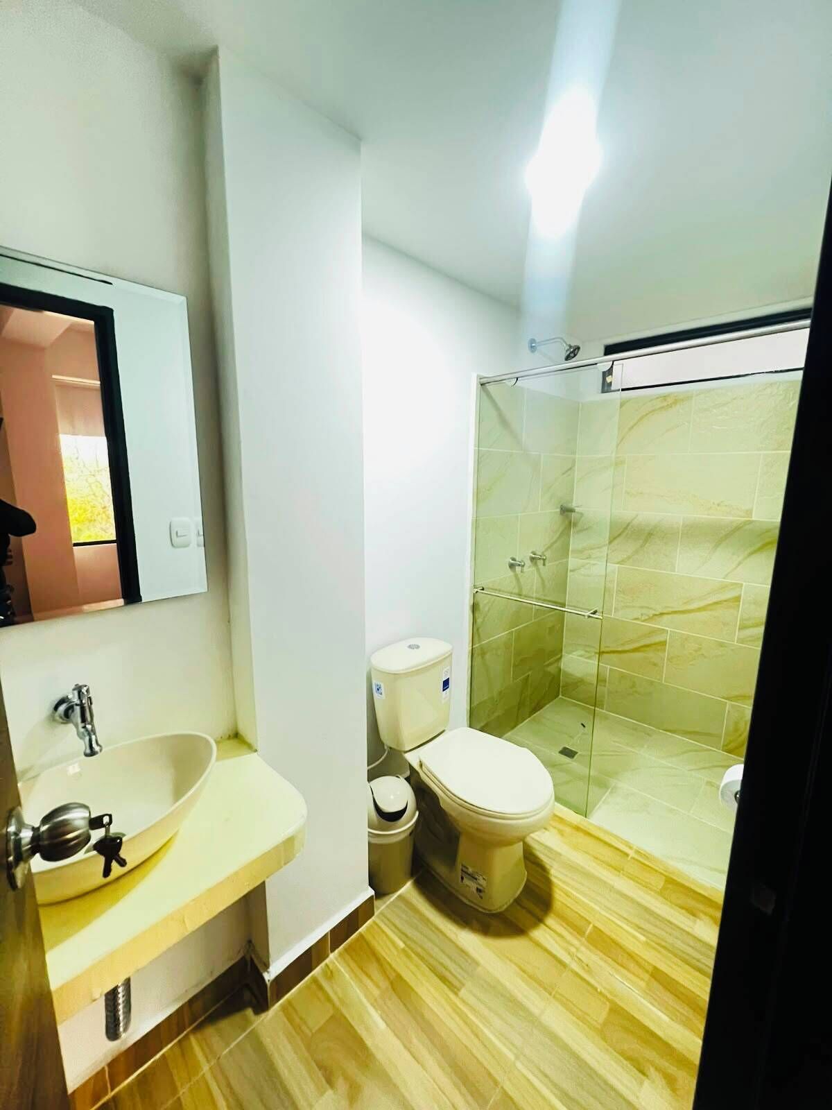 Une salle de bain équipée d’un lavabo, de toilettes et d’une douche à parois de verre.