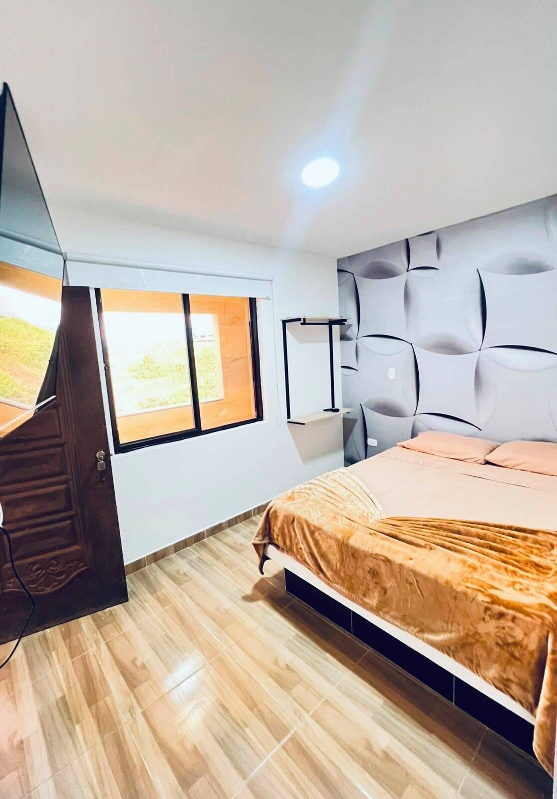 Ein Schlafzimmer mit Bett, Fenster, Kleiderschrank und Nachttisch.