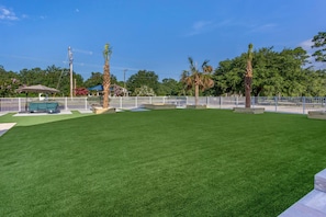 A well-maintained grassy area with a white fence, a bench, and a gazebo. - Days Inn By Wyndham Pawleys Island (Pawleys Island)