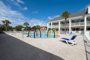 A pool area with colorful water features and lounge chairs.