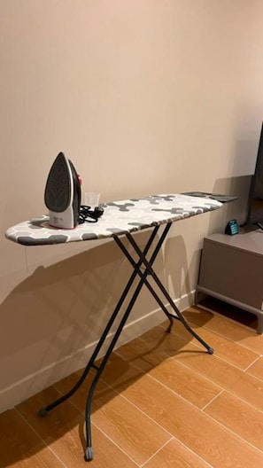 Ein platzsparender Bürostation mit klappbarem Tisch und einem tragbaren Bügeleisen.