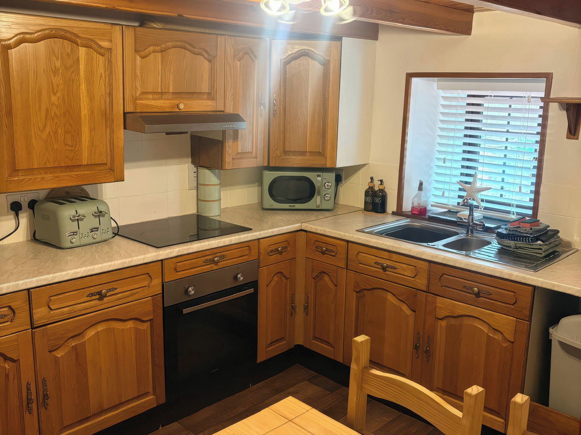 A kitchen with wooden cabinets, a microwave, a toaster, and a sink.