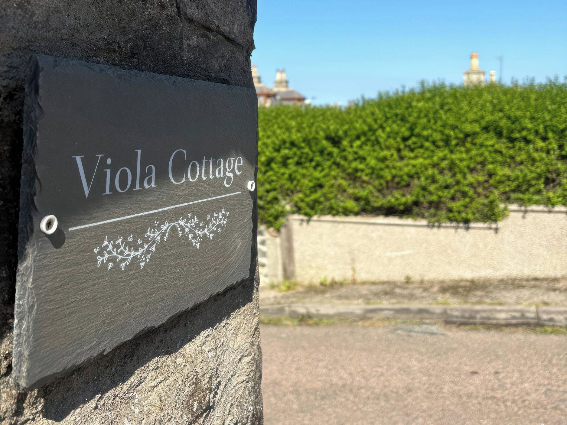 Señal para Cabaña Viola, con un diseño decorativo de hiedra.