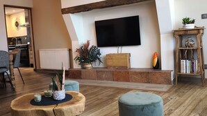 Ein modernes Wohnzimmer mit Kamin, Flachbildfernseher und einer gemütlichen Sitzecke.