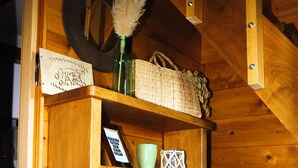 Une boîte de rangement en bois, portant l’inscription « BOÎTE DE RANGEMENT », contient divers objets, notamment une tasse verte, un cadre avec une photo et une boîte d’articles sur le thème de Disney.