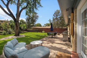 A patio with a seating area, a grill, and a table with chairs. - THE SUNSET HOUSE 3-Bedroom, 2-Bath House in Central Colorado Springs. (Colorado Springs)