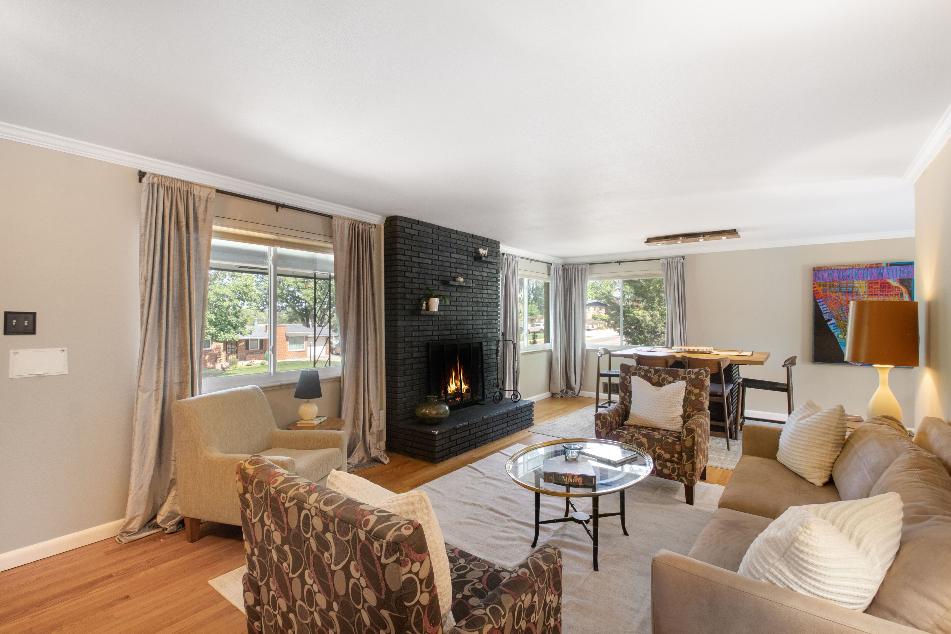 A living room with a fireplace, comfortable seating, and a view of the outdoors.