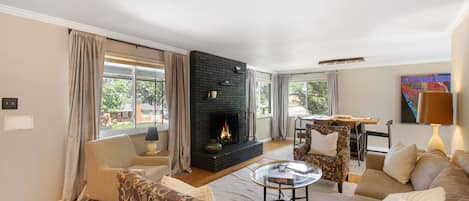 A living room with a fireplace, comfortable seating, and a view of the outdoors.