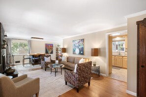 A spacious living room with a sofa, chairs, a coffee table, and a dining area with a table and chairs. - THE SUNSET HOUSE 3-Bedroom, 2-Bath House in Central Colorado Springs. (Colorado Springs)