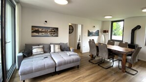 Ein modernes Wohnzimmer mit einer Couch, einem Esstisch, Stühlen und einem Kamin.