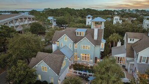 A residential area with multiple houses, including a prominent light blue house with a balcony and a tower-like structure. - Gulf Views, Private Pool and Golf Cart (Watersound)
