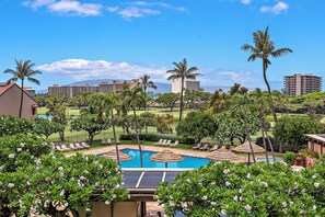 A resort with multiple swimming pools, palm trees, and a view of the ocean. - New Family Retreat Near Beaches & Whalers Village (Lahaina)
