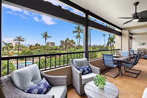 A balcony with wicker furniture, a table, and a grill. - New Family Retreat Near Beaches & Whalers Village (Lahaina)