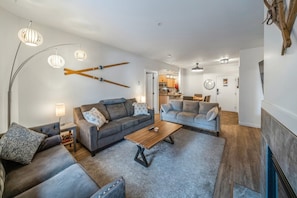 Ein modernes Wohnzimmer mit zwei Sofas, einem Couchtisch und einer Essecke im Hintergrund.