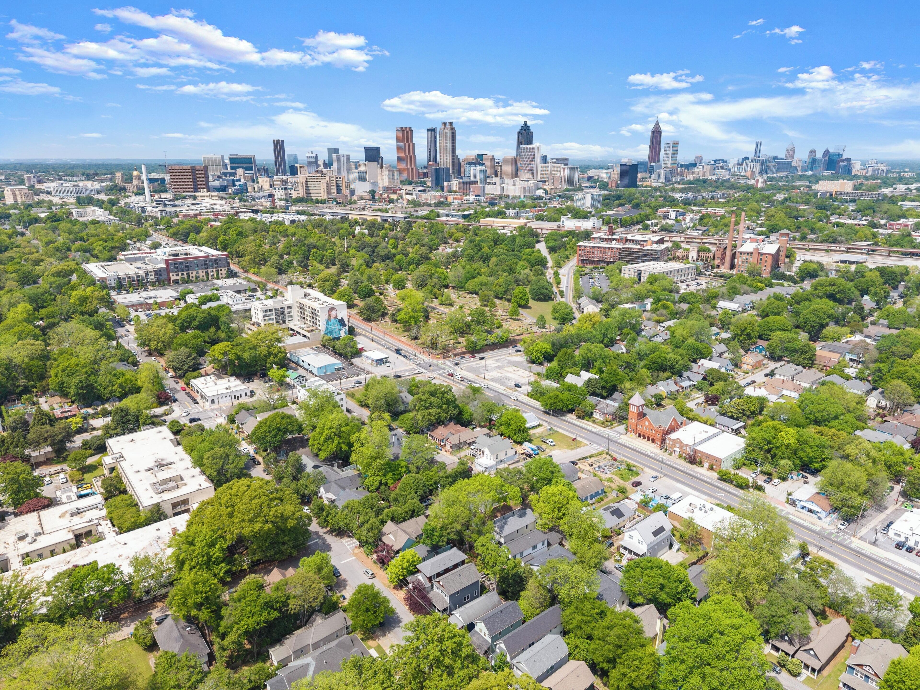 An aerial view of a city with a mix of residential and commercial buildings, roads, and a prominent skyline.