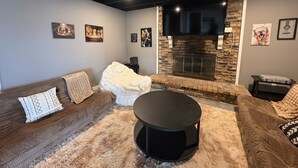A modern living room with a fireplace, comfortable seating, and artwork on the walls. - Barefoot Boho Bay - Morse - Cicero Indiana (Cicero)