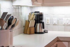 A kitchen with a Keurig coffee maker, a knife block, and a white countertop. - Waterfront Bunk Retreat w/ Pool, Jamaica Beach (Jamaica Beach)