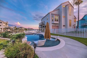 A residential property with a swimming pool, a well-maintained lawn, and a white picket fence. - Waterfront Bunk Retreat w/ Pool, Jamaica Beach (Jamaica Beach)