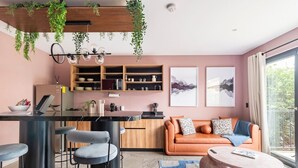 Una cocina moderna con barra, sofá y mesa de comedor.