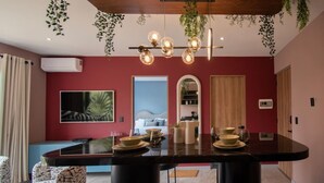 Un comedor moderno con una mesa negra, sillas y plantas colgantes.