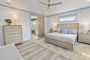 A bedroom with a bed, bedside tables, a wardrobe, a ceiling fan, and a window. - Shore Beats Work - Gulf Views, Pool, Elevator, Beach Access (Panama City Beach)