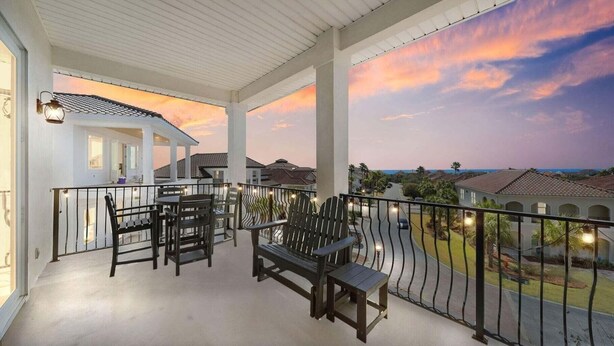 A balcony with outdoor furniture, a view of the neighborhood, and a sunset. - Shore Beats Work - Gulf Views, Pool, Elevator, Beach Access (Panama City Beach)